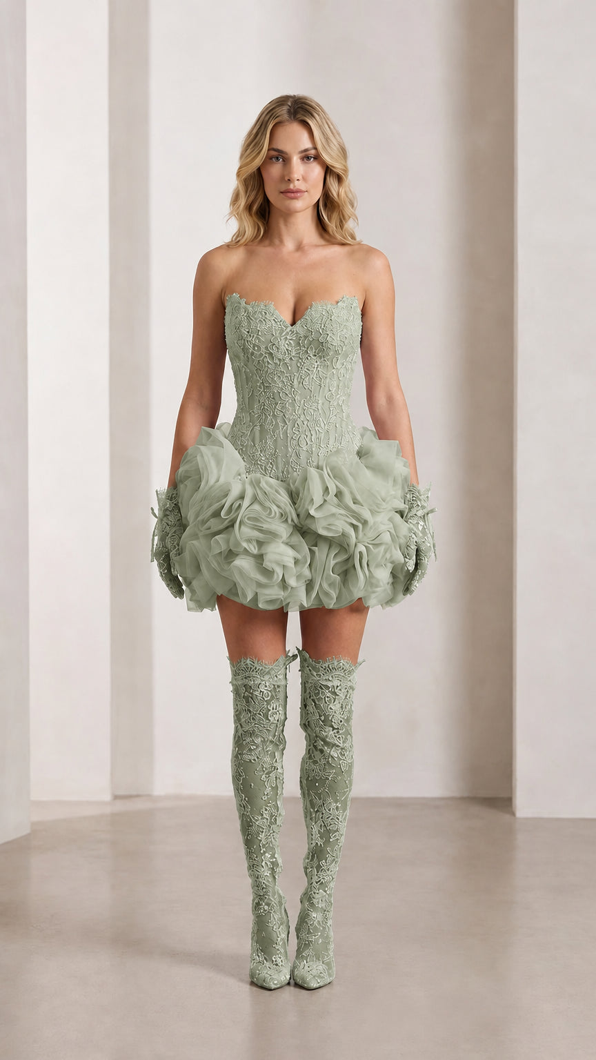 Model wearing sage green strapless lace corset mini dress with ruffled rosette bubble skirt