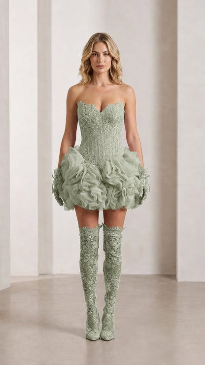 Model wearing sage green strapless lace corset mini dress with ruffled rosette bubble skirt