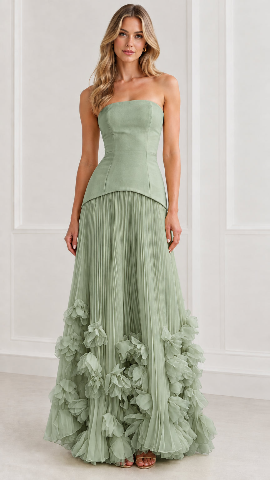 Front view of model wearing sage green strapless drop-waist pleated formal dress