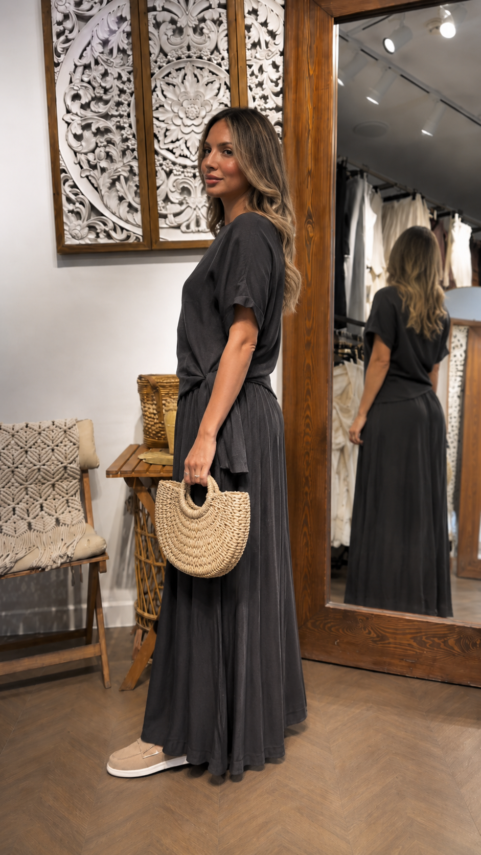 Side view of a charcoal short sleeve maxi dress with draped waist and flowing skirt