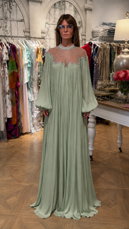 Front view of sage green pleated maxi dress with high neckline and embellished sheer bodice