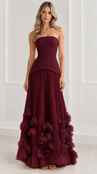 Front view of model wearing rich burgundy strapless corset pleated evening gown