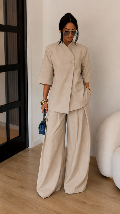 Front view of beige textured two-piece outfit with wrap-look top and flowing trousers