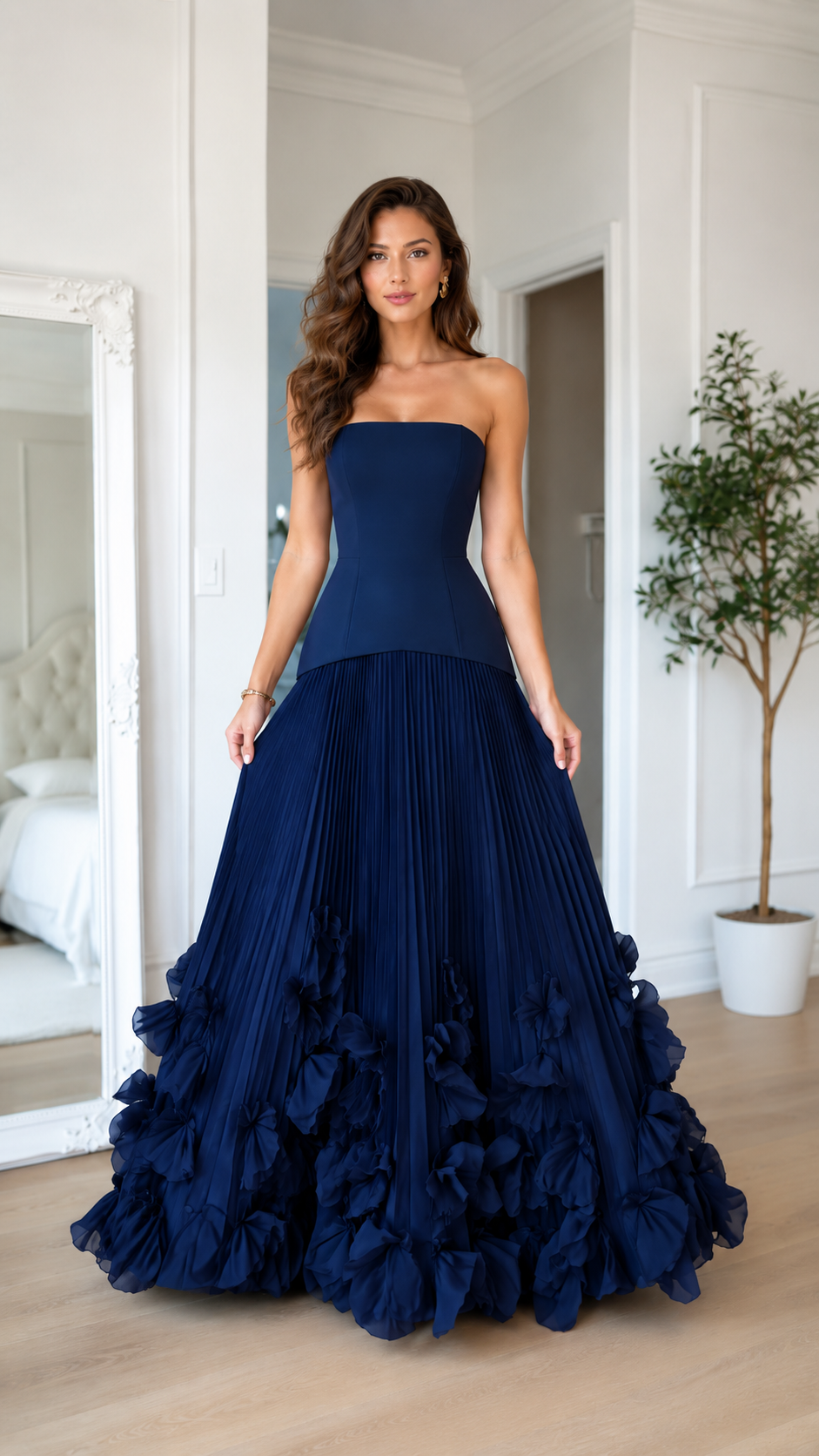 Front view of navy strapless pleated maxi gown with dramatic ruffle hem