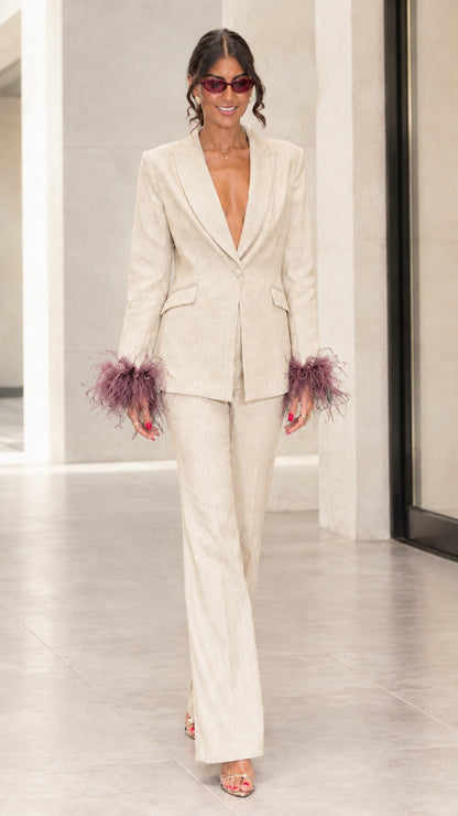 Front view of woman wearing champagne cream tailored suit set with mauve feather cuffs