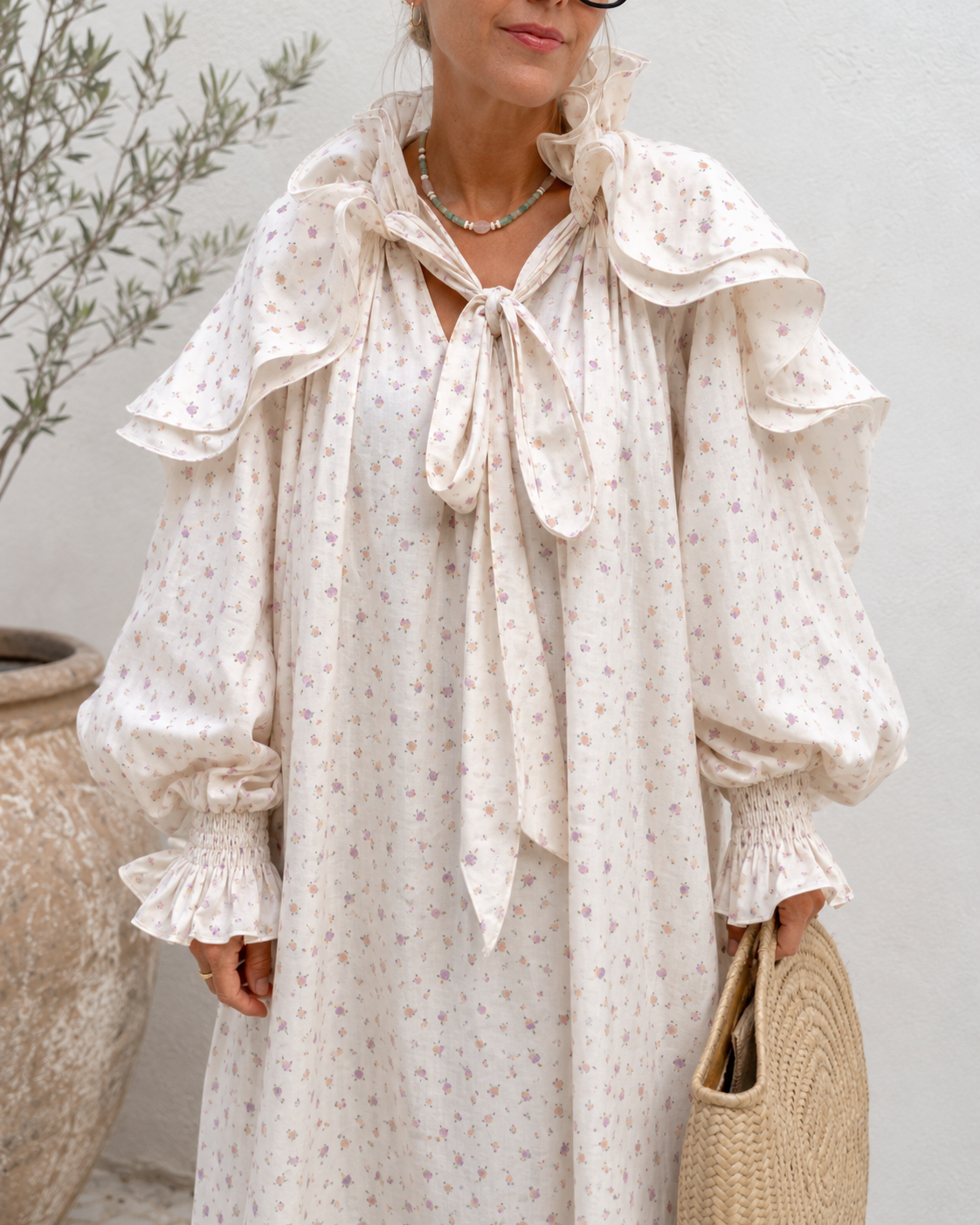 Detailed close-up of cream floral dress collar shoulder ruffles and sleeve cuffs