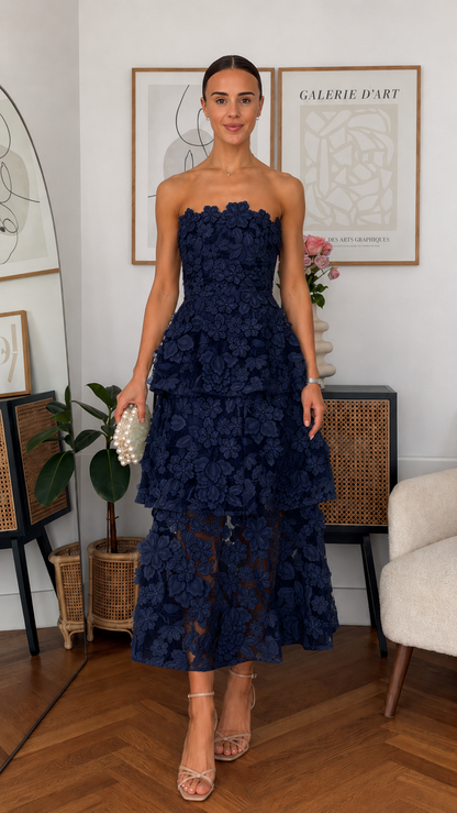 Front view of navy strapless 3D floral tiered midi dress