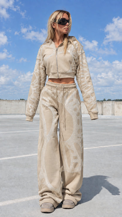 Model wearing beige tan rhinestone graphic tracksuit set
